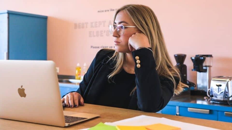 lady-at-desk-looking-past-her-laptop-in-office Lady at desk looking past her laptop in office
