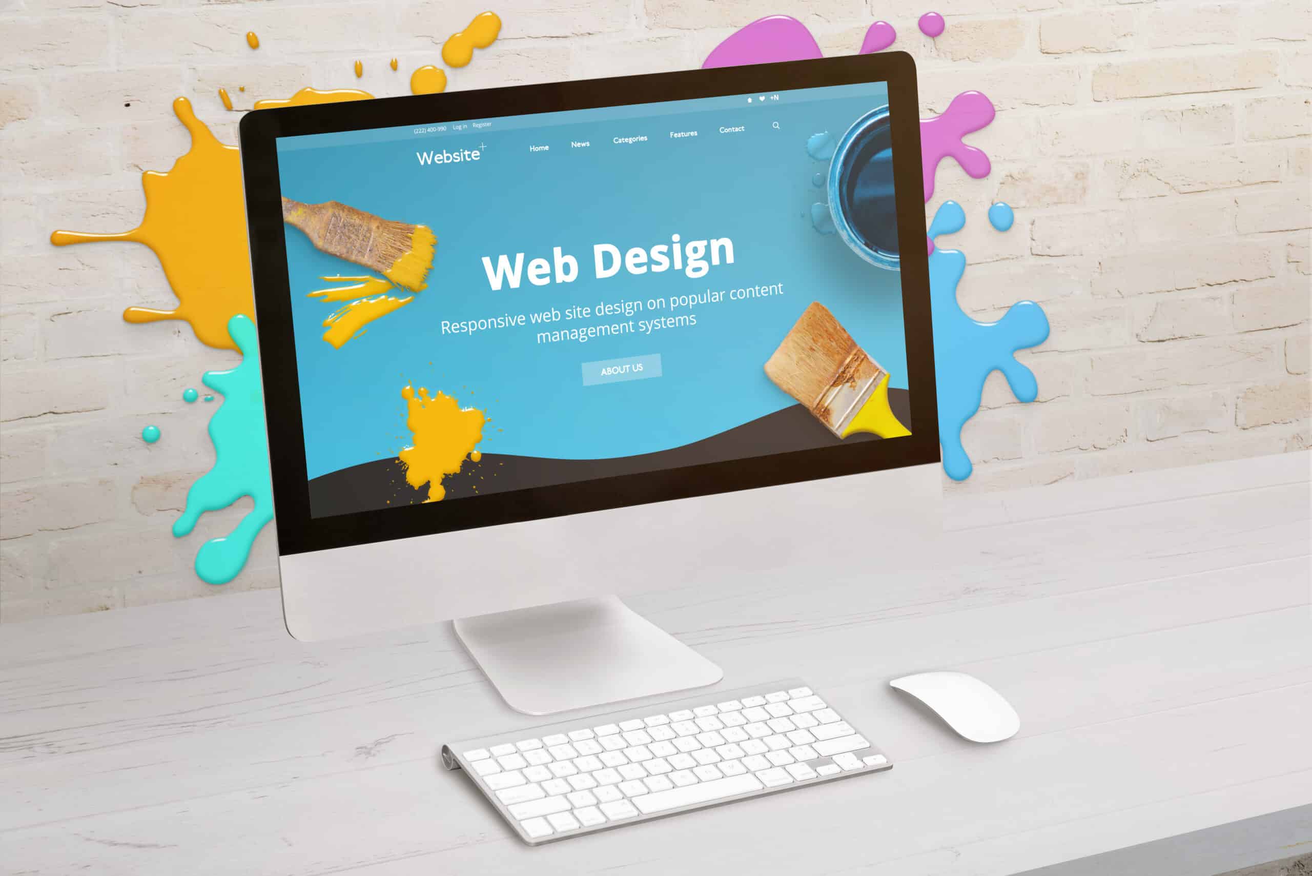 Computer screen with "Web Design" written on it and paint splattered around.