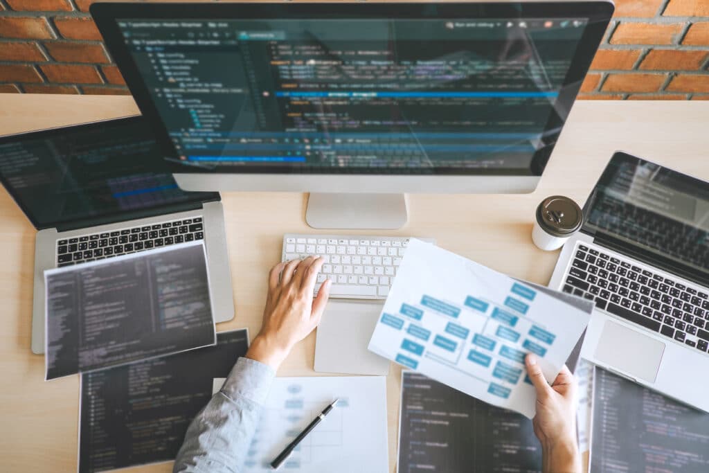 Man sitting at desk with a computer with lines of code on the screen. Man sitting at desk with a computer with lines of code on the screen.